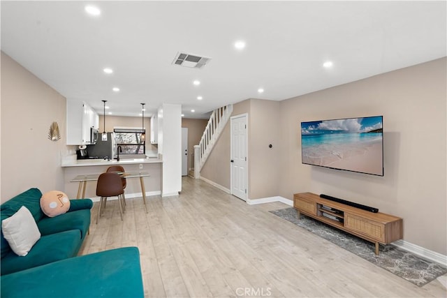12750 Centralia St Unit 215, Lakewood, CA 90715 - living area featuring stairway, light wood-style floors, recessed lighting, and baseboards