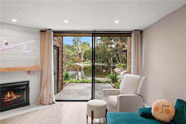 12750 Centralia St Unit 215, Lakewood, CA 90715 - doorway featuring wood finished floors, a water view, a large fireplace, and recessed lighting