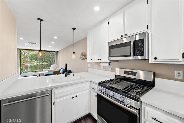 12750 Centralia St Unit 215, Lakewood, CA 90715 - kitchen featuring appliances with stainless steel finishes, light countertops, white cabinetry, and recessed lighting