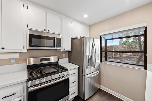 12750 Centralia St Unit 215, Lakewood, CA 90715 - kitchen featuring appliances with stainless steel finishes, dark wood-type flooring, baseboards, light countertops, and white cabinetry