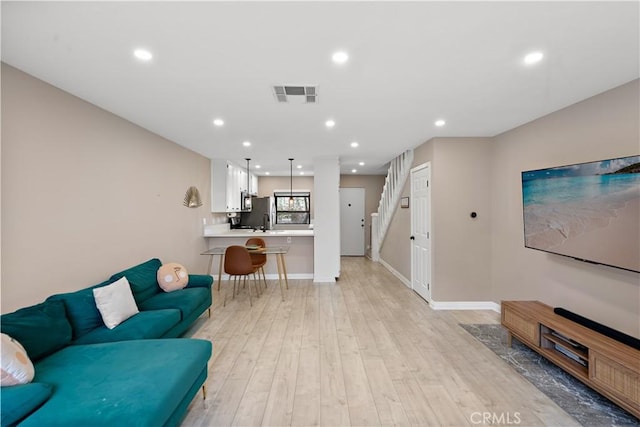 12750 Centralia St Unit 215, Lakewood, CA 90715 - living area featuring light wood-style floors, stairs, recessed lighting, and baseboards