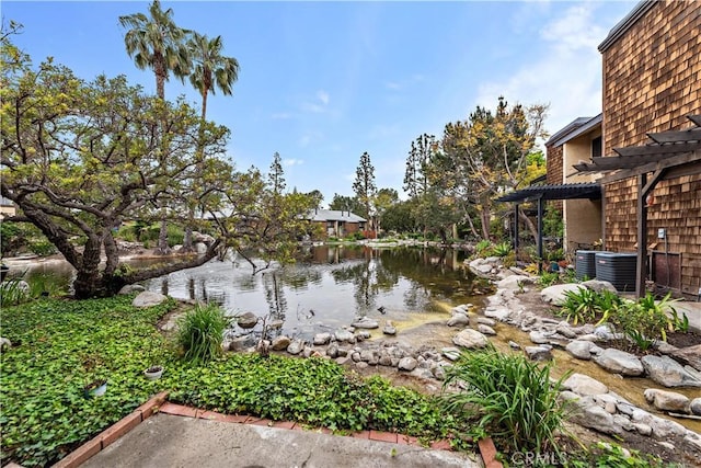 12750 Centralia St Unit 215, Lakewood, CA 90715 - view of yard featuring a pergola, a water view, and central air condition unit