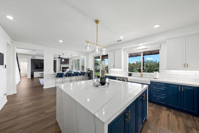 34056 Vandale Ct, Temecula, CA 92592 - kitchen featuring blue cabinetry, a sink, dark wood-style floors, decorative backsplash, and white cabinetry