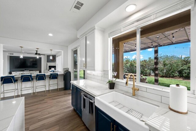 34056 Vandale Ct, Temecula, CA 92592 - kitchen featuring a sink, open floor plan, ceiling fan, dark wood finished floors, and blue cabinetry