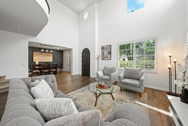 34056 Vandale Ct, Temecula, CA 92592 - living area with wood finished floors, a high ceiling, healthy amount of natural light, baseboards, and arched walkways