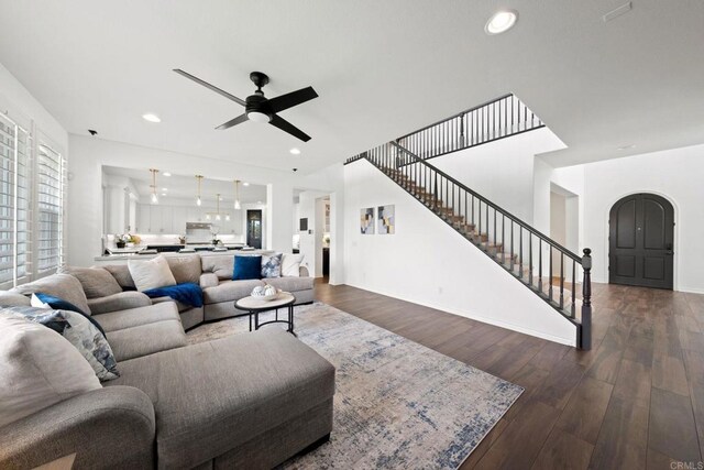 34056 Vandale Ct, Temecula, CA 92592 - living area featuring stairway, dark wood-style flooring, ceiling fan, baseboards, and arched walkways