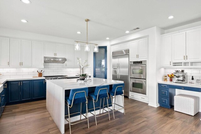 34056 Vandale Ct, Temecula, CA 92592 - kitchen with appliances with stainless steel finishes, blue cabinetry, decorative backsplash, white cabinets, and a kitchen island