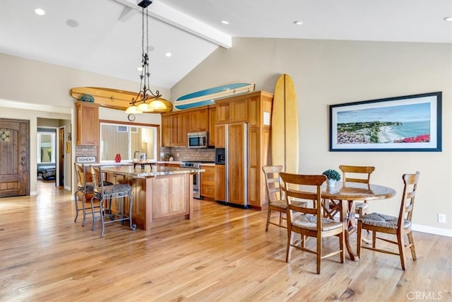 33441 N Spinnaker Dr N, Dana Point, CA 92629 - kitchen featuring appliances with stainless steel finishes, backsplash, light wood-style floors, a kitchen island, and a breakfast bar area