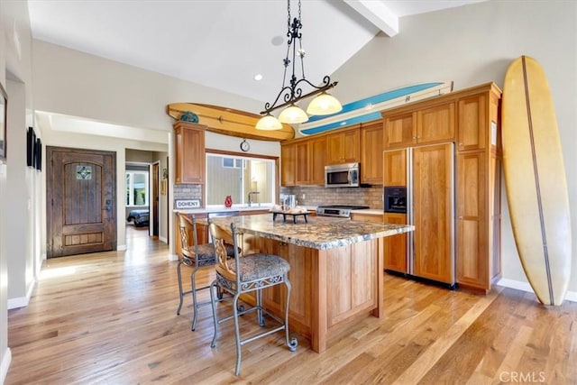 33441 N Spinnaker Dr N, Dana Point, CA 92629 - kitchen featuring stainless steel appliances, beam ceiling, backsplash, a kitchen island, and a breakfast bar area