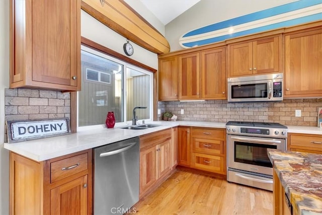 33441 N Spinnaker Dr N, Dana Point, CA 92629 - kitchen featuring stainless steel appliances, a sink, vaulted ceiling, tasteful backsplash, and light wood-type flooring