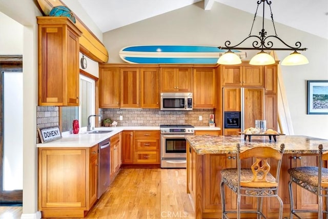 33441 N Spinnaker Dr N, Dana Point, CA 92629 - kitchen featuring appliances with stainless steel finishes, a sink, lofted ceiling, light wood-style floors, and tasteful backsplash