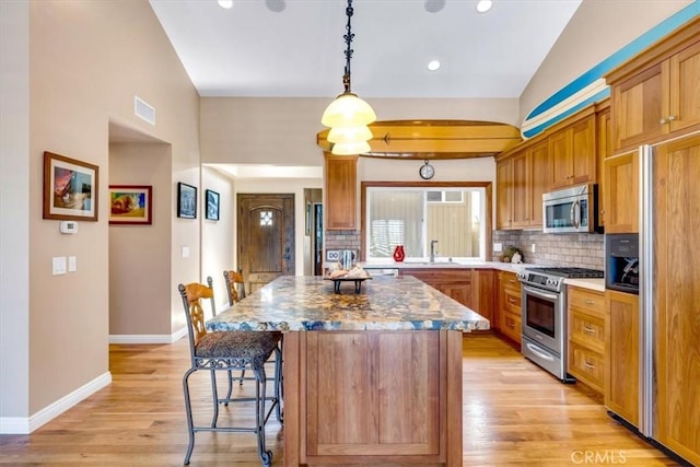 33441 N Spinnaker Dr N, Dana Point, CA 92629 - kitchen with appliances with stainless steel finishes, a sink, backsplash, a kitchen island, and a kitchen bar
