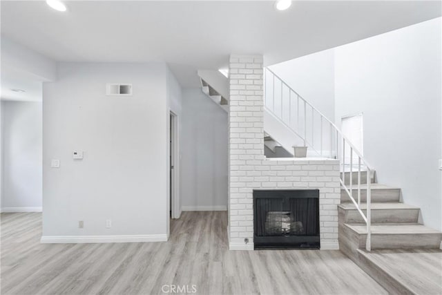 72 S Greenwood Ave Unit 3, Pasadena, CA 91107 - unfurnished living room featuring stairway, wood finished floors, baseboards, recessed lighting, and a fireplace