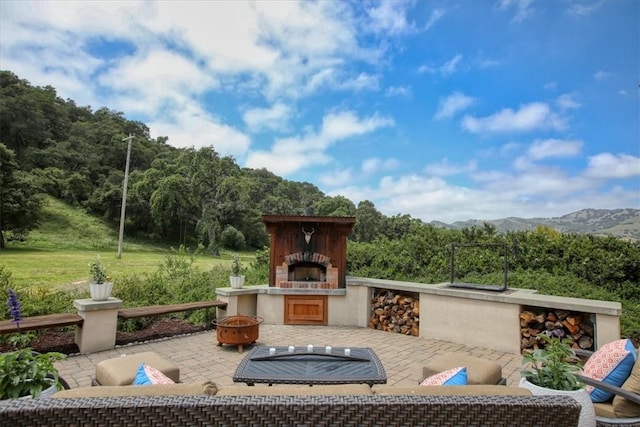 7550 Mary Hall Rd, Arroyo Grande, CA 93420 - view of patio featuring an outdoor fireplace, a mountain view, and a wooded view