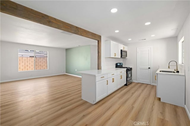 3316 Roxbury St, Rosamond, CA 93505 - kitchen featuring appliances with stainless steel finishes, light wood-style flooring, light countertops, white cabinets, and plenty of natural light