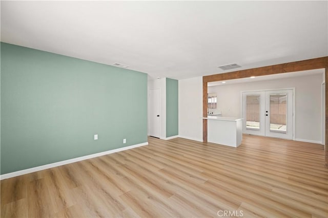 3316 Roxbury St, Rosamond, CA 93505 - unfurnished living room featuring french doors, light wood-style floors, and baseboards