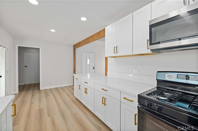 3316 Roxbury St, Rosamond, CA 93505 - kitchen featuring gas range, stainless steel microwave, white cabinetry, light countertops, and recessed lighting