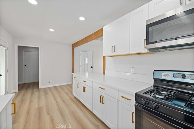 3316 Roxbury St, Rosamond, CA 93505 - kitchen with black range with gas stovetop, stainless steel microwave, white cabinetry, light countertops, and recessed lighting