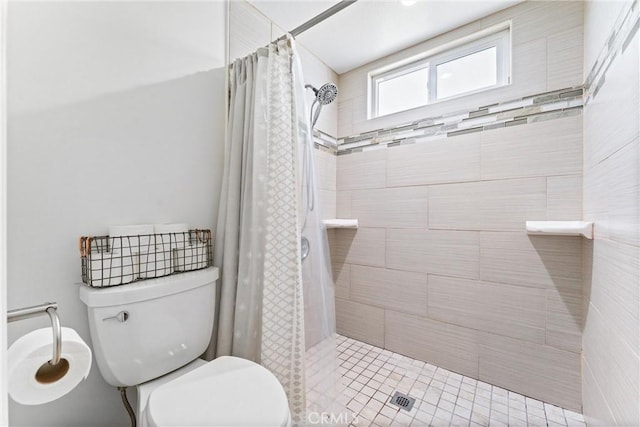 full bath with a tile shower and toilet