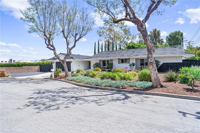 single story home featuring fence, concrete driveway, an attached garage, and a tile roof