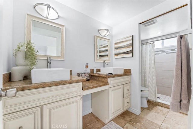 full bath with tiled shower, double vanity, and toilet