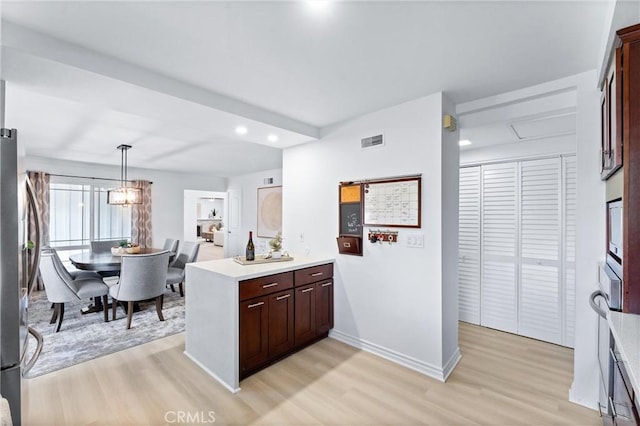 kitchen featuring light wood-style flooring, a peninsula, light countertops, baseboards, and recessed lighting