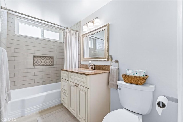 bathroom featuring toilet, shower / bath combination with curtain, and vanity