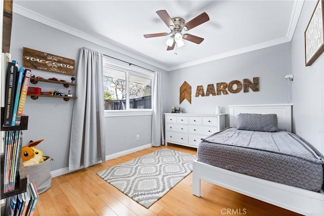 bedroom featuring crown molding, wood finished floors, baseboards, and a ceiling fan