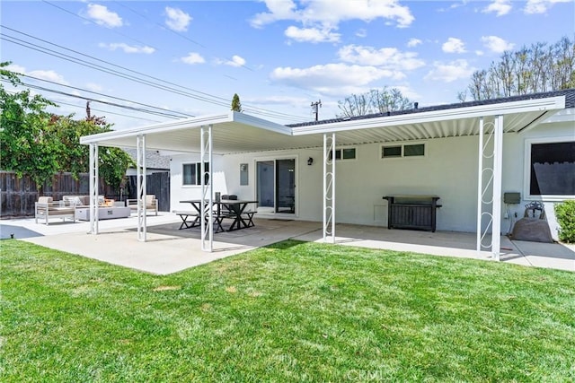 rear view of property featuring outdoor lounge area, a patio, and stucco siding