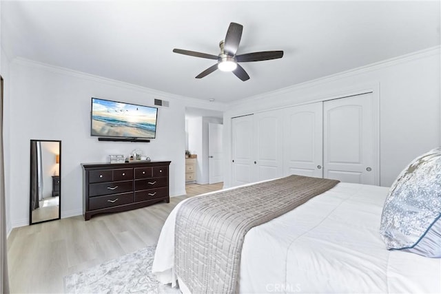 bedroom with light wood finished floors, crown molding, a closet, ceiling fan, and baseboards