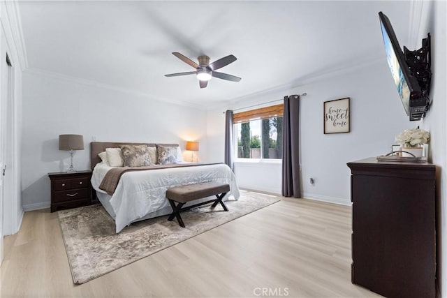 bedroom featuring light wood-style flooring, ornamental molding, baseboards, and ceiling fan