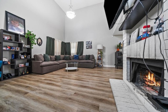 living room with high vaulted ceiling, wood finished floors, and a fireplace