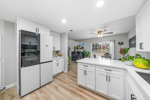 kitchen featuring high end fridge, a peninsula, white cabinetry, a ceiling fan, and light countertops