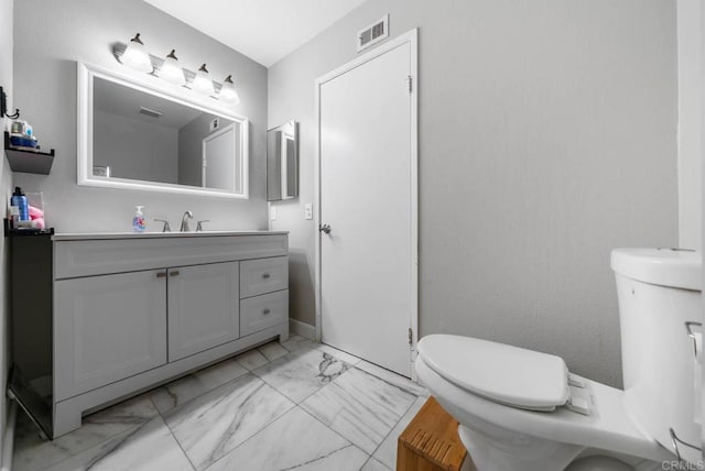 half bath with marble finish flooring, toilet, and vanity