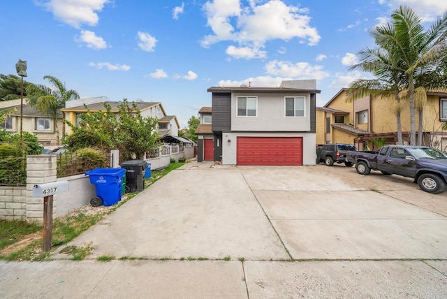 view of front of home featuring an attached garage, stucco siding, driveway, and a residential view
