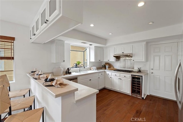 2405 Marshallfield Ln Unit B, Redondo Beach, CA 90278 - kitchen with wine cooler, under cabinet range hood, a peninsula, a sink, and light countertops