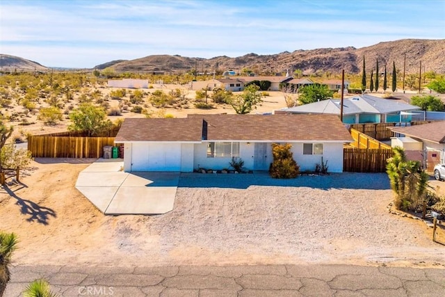 view of front of house featuring a mountain view and fence