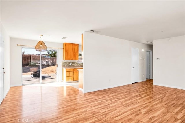 unfurnished living room with light wood finished floors and baseboards