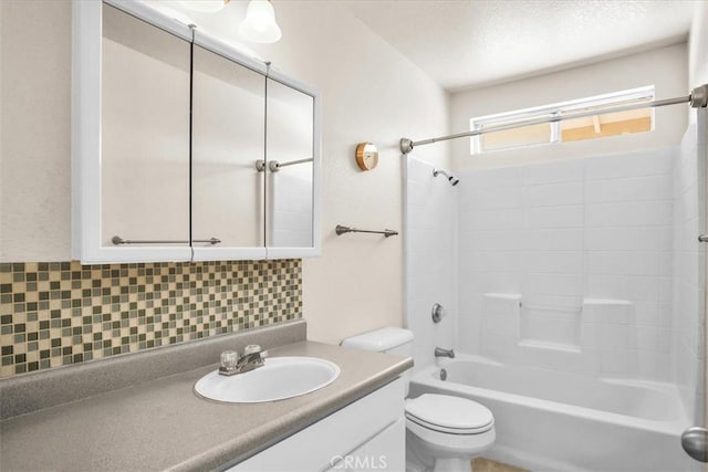 bathroom featuring toilet, decorative backsplash, vanity, and shower / bath combination
