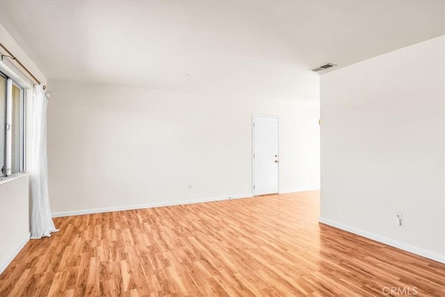 empty room with light wood finished floors and baseboards