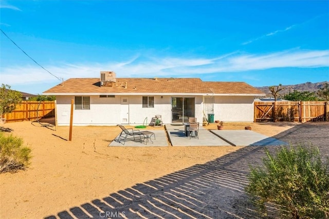 back of house featuring a patio area, a fenced backyard, stucco siding, and central AC