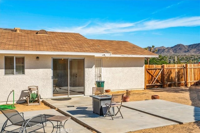 view of patio with a fire pit, a mountain view, and fence