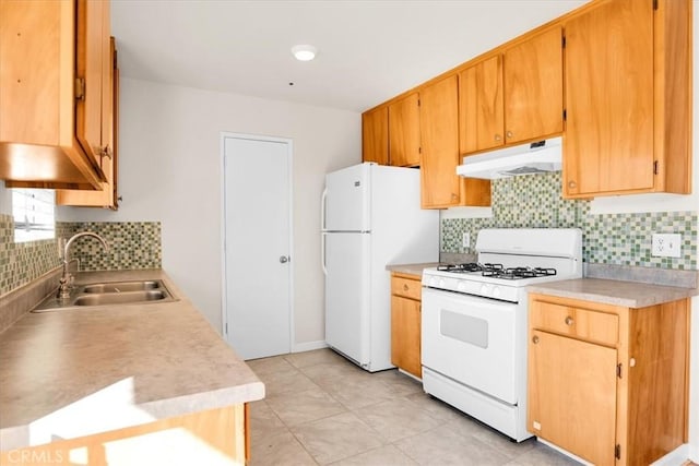 kitchen with white appliances, under cabinet range hood, a sink, decorative backsplash, and light countertops