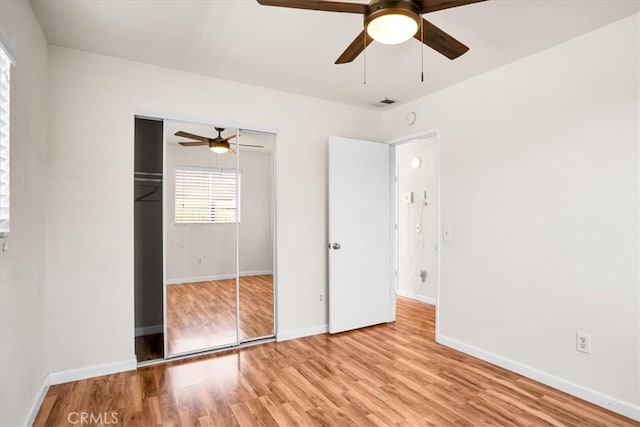 unfurnished bedroom with a closet, light wood finished floors, baseboards, and ceiling fan
