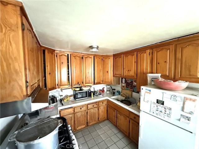 106 N Encina Ave, Rialto, CA 92376 - kitchen with freestanding refrigerator, a sink, brown cabinetry, and light tile patterned floors