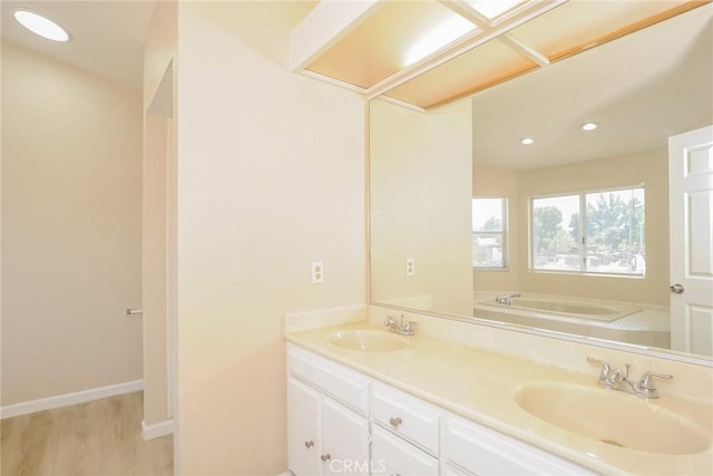 1536 Granicy Dr, Lancaster, CA 93535 - full bathroom featuring wood finished floors, double vanity, a bath, recessed lighting, and baseboards