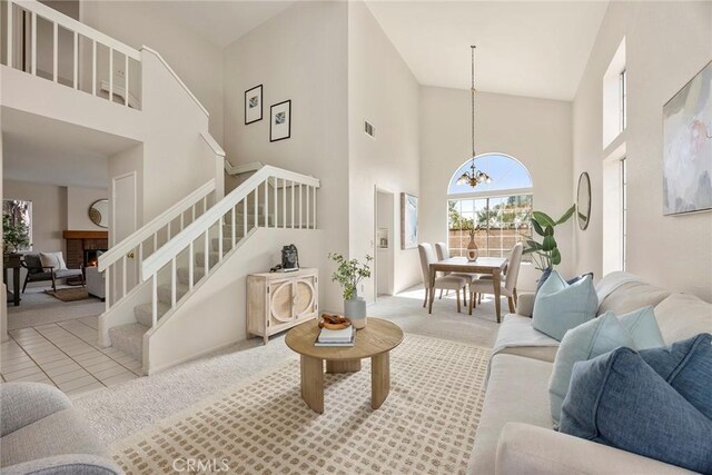 13639 Meadow Crest Dr, Chino Hills, CA 91709 - living area with a high ceiling, a chandelier, carpet, stairs, and a warm lit fireplace