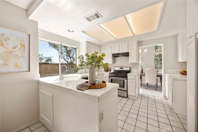 13639 Meadow Crest Dr, Chino Hills, CA 91709 - kitchen featuring stainless steel range with gas stovetop, a sink, tile countertops, under cabinet range hood, and healthy amount of natural light