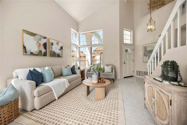 13639 Meadow Crest Dr, Chino Hills, CA 91709 - living room featuring high vaulted ceiling, stairway, light carpet, baseboards, and a chandelier