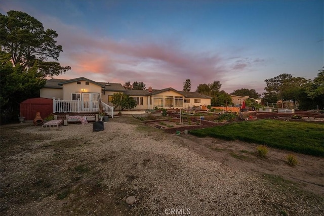 1561 Cielo Ln, Nipomo, CA 93444 - back of property at dusk featuring a vegetable garden and a deck